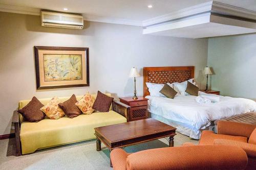 pokój hotelowy z łóżkiem i kanapą w obiekcie RIETONDALE LODGE w mieście Pretoria