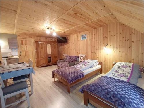1 dormitorio con 2 camas en una habitación de madera en Pokoje gościnne u Beatki, en Czarna Góra