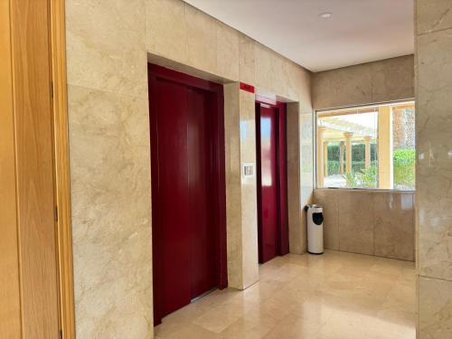 a hallway with two red doors and a window at Natura playa By Sunset in La Venteta