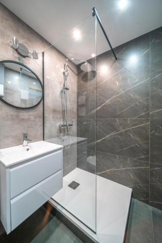 a bathroom with a sink and a glass shower at Verde Apartment SelfCheck-in 24h in Wrocław