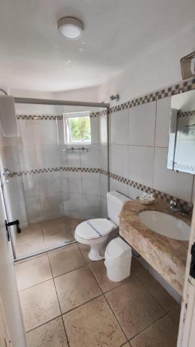 a bathroom with a toilet and a sink at Hotel Camboa Antonina - PR in Antonina