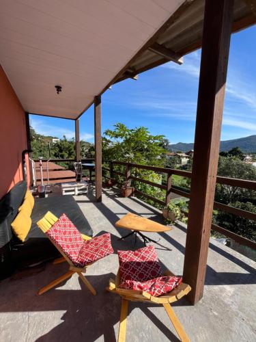2 Stühle und ein Tisch auf einem Balkon mit Aussicht in der Unterkunft Vibe House Hostel in Florianópolis