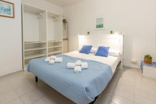 een slaapkamer met een groot bed met handdoeken erop bij Apartamento en Tossa de Mar a 3 min de la playa in Tossa de Mar
