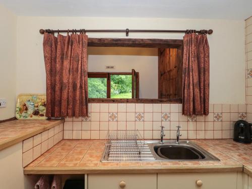 - une cuisine avec un évier et un miroir dans l'établissement The Wagon House, à Bicknoller