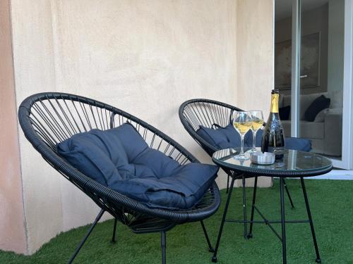 2 chaises avec des oreillers bleus assises à côté d'une table dans l'établissement Le Somptueux, Cosy / Balnéo, à Carcassonne