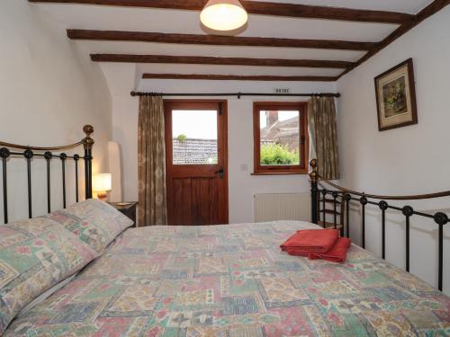 a bedroom with a bed and a window at The Wagon House in Bicknoller