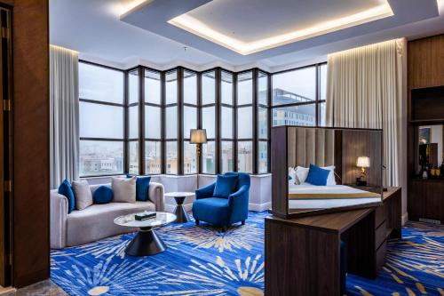 a hotel room with a king sized bed and a living room at Novo Hotel in Riyadh