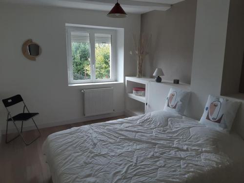 une chambre blanche avec un grand lit avec une fenêtre dans l'établissement Maison de caractère proche mer 6 lits 2SdB 2wc, à Plouhinec