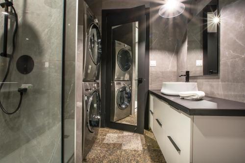 a bathroom with a sink and a washing machine at Les Lofts de la Gare - Par Les Lofts Vieux-Québec in Quebec City