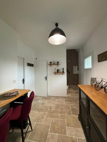 une cuisine avec une table et des chaises et une chambre avec une porte dans l'établissement LE 911, à Nazelles-Négron