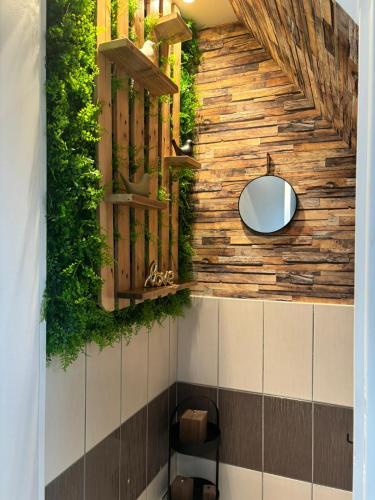 La salle de bains est pourvue d'un miroir et de plantes sur le mur. dans l'établissement LE 911, à Nazelles-Négron