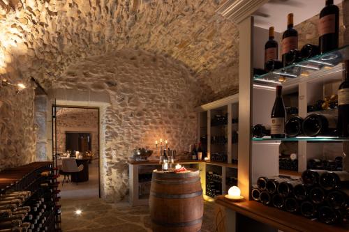 una sala de cata de vinos con barril y botellas de vino en Château Les Oliviers de Salettes, en Charols