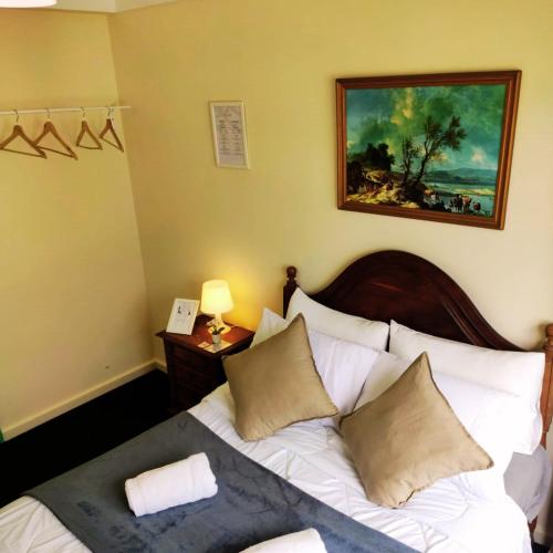 a bedroom with a bed with a painting on the wall at Liberdade Home Royal direito in Braga
