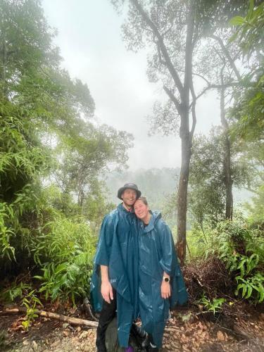 a man and woman in raincoats standing in a forest at Wisma Batu Mandi in Bukit Lawang