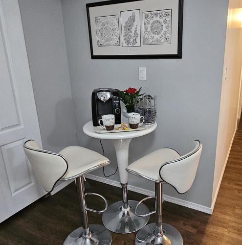 a small table with two chairs and a table with a coffee maker at Comfy KING Bed, Large private Basement Suite, Smart TV in Penticton- city of PEACHES AND BEACHES in Penticton
