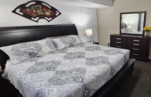 1 dormitorio con cama, tocador y espejo en Comfy KING Bed, Large private Basement Suite, Smart TV in Penticton- city of PEACHES AND BEACHES en Penticton