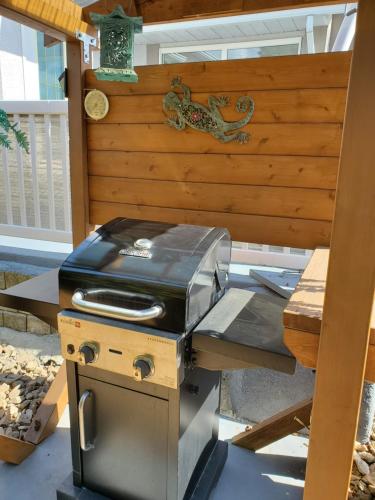 a grill sitting on a table next to a wooden wall at Comfy KING Bed, Large private Basement Suite, Smart TV in Penticton- city of PEACHES AND BEACHES in Penticton