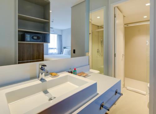 a bathroom with a sink and a mirror at Radisson São Paulo Paulista in Sao Paulo