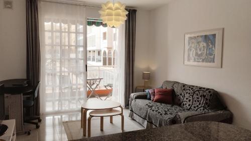 un soggiorno con un divano e un tavolo di Almichara a El Médano