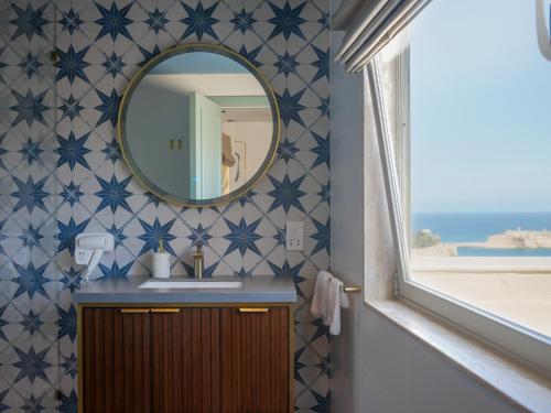 W łazience znajduje się umywalka i lustro. w obiekcie Battery House w mieście Valletta