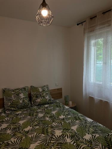 Résidence Camus في بلوا: غرفة نوم مع سرير لحاف أخضر و أبيض