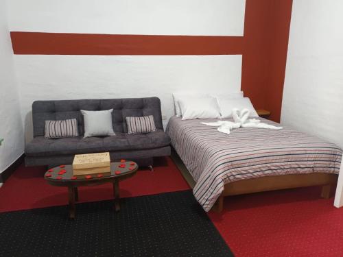 ein Schlafzimmer mit einem Bett und einem Sofa in der Unterkunft Hotel Casita de Belén in Sonsón