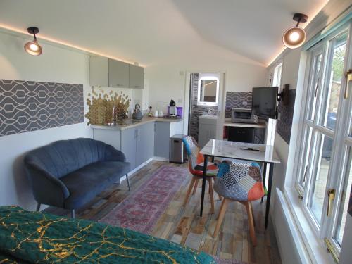 a room with a bed and a table and a kitchen at The Cabin in Pakenham