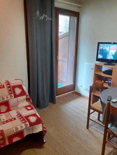 Cette chambre comprend un lit et une porte coulissante en verre. dans l'établissement Studio cozy, à Saint-Gervais-les-Bains