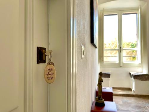 a door with a tag on it next to a window at Sardinian Gallery Domus in Bosa