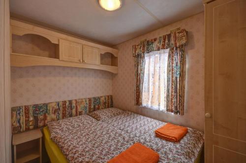 a small bedroom with a bed and a window at Apartmány Stříbrňák in Hradec Králové