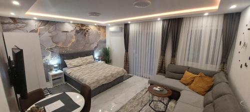 niewielka sypialnia z łóżkiem i kanapą w obiekcie GOLD APARTMANI w mieście Prokuplje