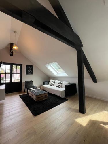 Cette chambre mansardée comprend un lit et une chaise. dans l'établissement Appartement spacieux et lumineux proche du centre historique, à Dol-de-Bretagne