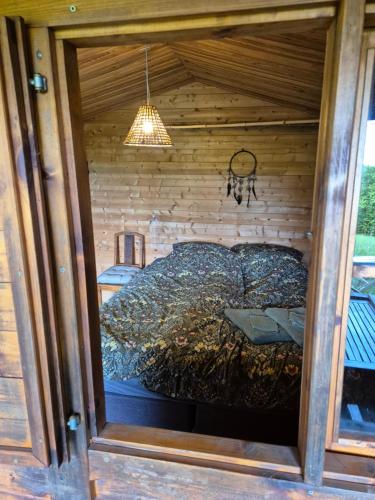 a bed in a room in a wooden house at wooden cabin in nature in Troche
