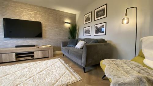 a living room with a couch and a flat screen tv at Whittaker Mews near Alton Towers JCB in Rocester