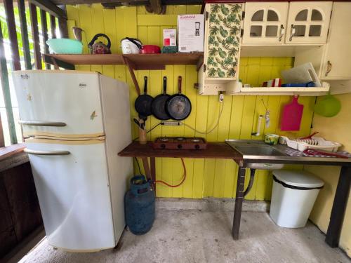 a kitchen with a white refrigerator and a sink at Casa Mamré in Cahuita