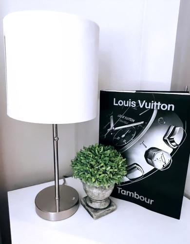 a lamp and a vase with a plant on a table at Downtown Luxury Studio in Dallas