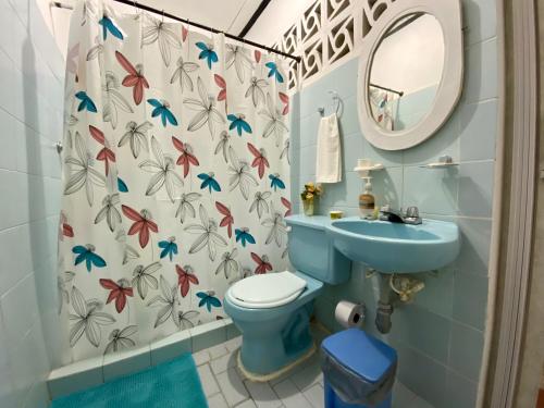 y baño con aseo azul y lavamanos. en Habitación Multiple cerca de aeropuerto en Cartagena de Indias