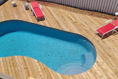 馬頭城的住宿－6812 Beach Rd, Semi Oceanfront, Pool, Hot Tub，蓝色游泳池,配有两把椅子和一双毛巾