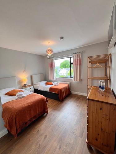 1 dormitorio con 2 camas y ventana en Greenville B&B en Kenmare