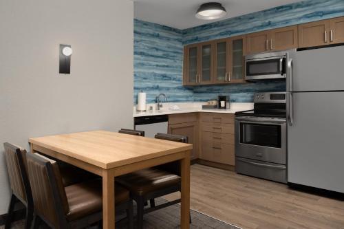 a kitchen with a wooden table and a refrigerator at Residence Inn Palo Alto Los Altos in Palo Alto