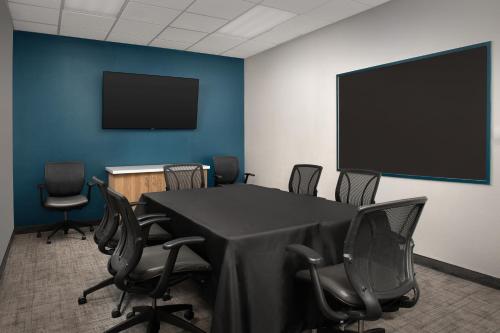 a conference room with a table and chairs and a screen at Residence Inn Palo Alto Los Altos in Palo Alto