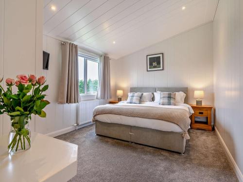 2 Bed in St Andrews 94606 في سانت أندروز: غرفة نوم بسرير و إناء من الزهور