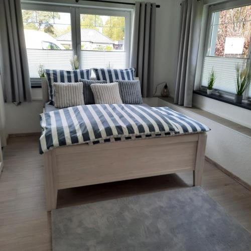 a couch sitting in a room with two windows at FeWo Im Grünen in Lilienthal