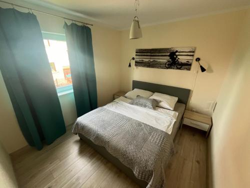 a small bedroom with a bed and a window at Nemo - apartament, domek w Gaskach in Gąski