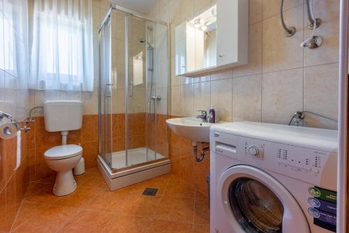 a bathroom with a washing machine and a sink at Family house with swimming pool in Novi Vinodolski