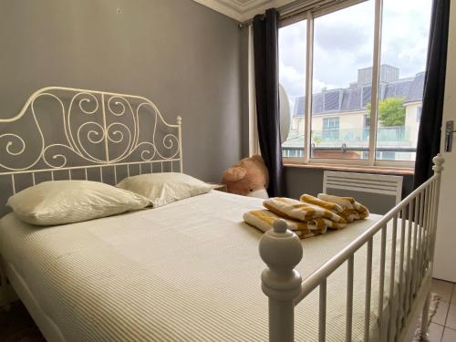 - un lit blanc dans une chambre avec fenêtre dans l'établissement L'appartement des Champs Elysées, à Paris