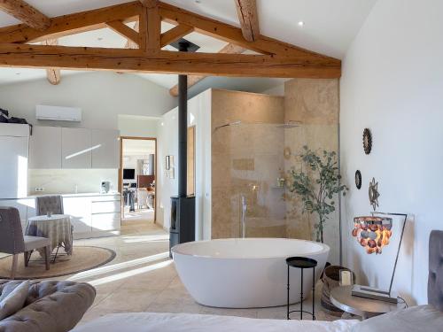 - une grande baignoire blanche dans une chambre avec cuisine dans l'établissement Mas La Rose Sauvage - magnificent Luberon views, à Murs