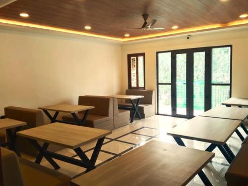 a dining room with tables and chairs and windows at The Bassu's Gangtok in Gangtok