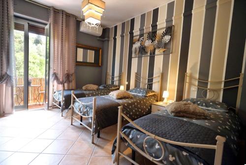 a room with three beds and a balcony at L'Oasi tra mare e monti in Lerici