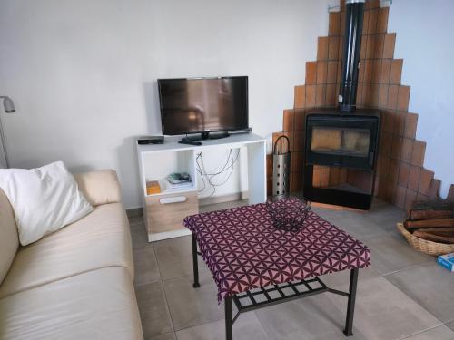 uma sala de estar com um sofá, uma mesa e uma televisão em Casa Azotea mit Dachterasse em Tijarafe